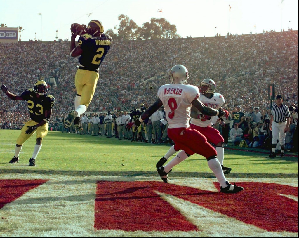 Michigan's cornerback Charles Woodson (2) leaps to make an interception in the end zone in the first half on a pass from Washington State's Ryan Leaf during the 84th Rose Bowl in Pasadena, Calif., Thursday, Jan. 1, 1998. Watching the play are Michigan's William Peterson (23) and Washington States Kevin McKenzie (9).