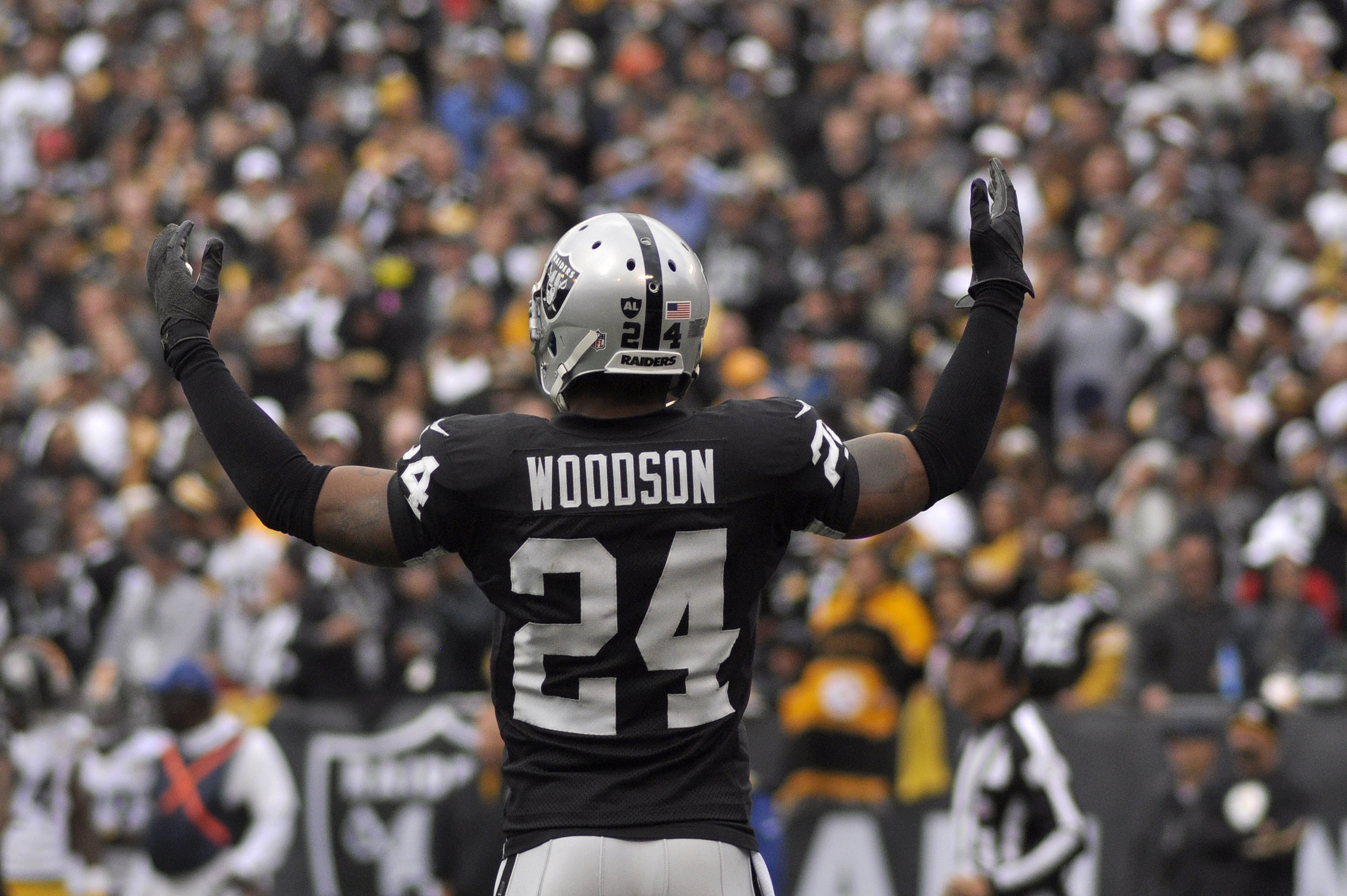 Oakland Raiders cornerback Charles Woodson (24) pumps up the crowd during the football game against the Pittsburgh Steelers at O.co Coliseum in Oakland, Calif., on Sunday, Oct. 27, 2013. The Raiders won 21-18. 